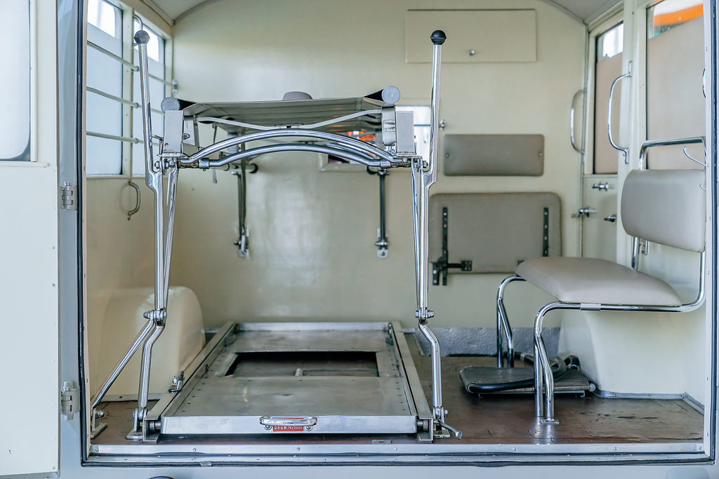 Mercedes-Benz Museum. Collection Room 3: Gallery of Helpers. Mercedes-Benz 320 ambulance (W 142) from 1937. View inside the patient compartment with space for stretchers (left) and bench seat for attending personnel.